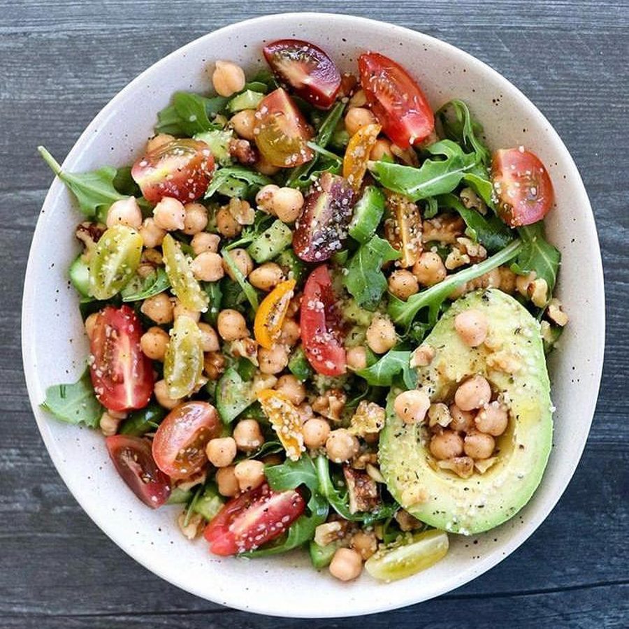 Un saladier du soir bien garni : roquette, tomates, concombre, pois chiches, avocat et noix.